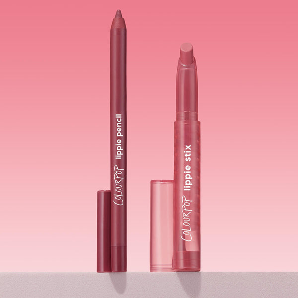 ColourPop Got Pink? Lippie Stix + Pencil Set showing a rosy mauve lip pencil and matching Lippie Stix standing uncapped with translucent pink caps beside them on a light shelf against a pink gradient background; ColourPop Lippie Stix + Pencil Set.