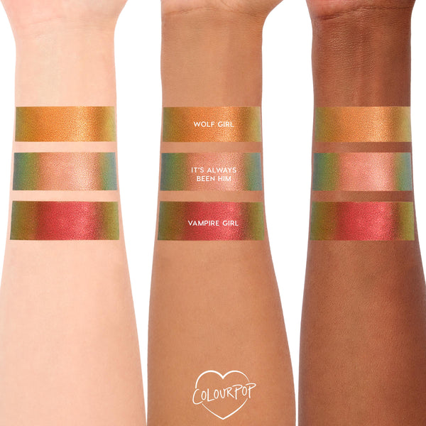 ColourPop Shadow Stix Love Triangle arm swatches shown on light, medium, and deep skin: Wolf Girl duochrome gold-green, It’s Always Been Him peach shimmer, and Vampire Girl red-gold, photographed against a clean white backdrop.