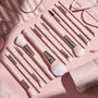 Smoke 'N Roses Brush Roll displaying a full ColourPop Makeup Brush Kit: pink-handled powder, blush, eyeshadow, angled liner, and spoolie brushes with silver ferrules, arranged in a flat lay beside a blush-pink roll-up case embossed ColourPop.