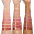 Glossy lip oil swatches, from clear to rose and deep berry, shown on three arms in light, medium, and deep skin tones, labeled Lychee Jelly, Flirty Text, Baby Panda, It’s a Date, Trending Now, So Sassy, Hits Diff, Beverly Drive; ColourPop 100% Juicy So Juicy Lip Oil Set.