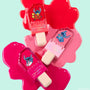 ColourPop Keepin’ It Sweet Ultra Glossy Lip trio shaped like popsicles featuring Disney Lilo and Stitch artwork, arranged on bright melted pink gloss pools against a mint background for a fun summer lip gloss display.