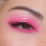 Glossy eyelid wearing In The Clear Face & Eye Gloss layered over vibrant pink eyeshadow, creating a glassy wet-look on a brown eye with long lashes and a defined brow; ColourPop Face & Eye Gloss product detail.