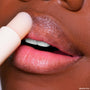 Vanilla Kisses lip scrub stick buffs dry flakes as it glides across soft, glossy lips, a close-up showcasing the creamy vanilla exfoliant from the ColourPop Lip Care Set for smooth, hydrated lip care.