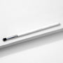 ColourPop Small Tapered Brush resting diagonally on a white textured platform, featuring a slim white handle, chrome ferrule, and small tapered black-and-white bristles for precise eyeshadow blending and detail work.
