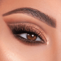Bronze shimmer eye look showcases Bare Necessities ColourPop Shadow Palette, blending warm matte neutrals with copper glitter on the lid, soft brown crease, and champagne inner-corner highlight, framed by full lashes and a groomed brow.
