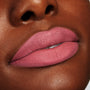 Lips wearing After Shock ColourPop Lippie Stix in a matte dusty rose, delivering smooth full-coverage color; close-up beauty swatch on skin shows creamy texture and crisp edges for precise application.
