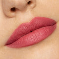 Close-up lips wearing ColourPop Lippie Stix After Shock, a soft-matte rosy pink, showing full, even coverage and creamy texture; swatch shot under bright studio lighting to highlight color payoff and smooth finish.