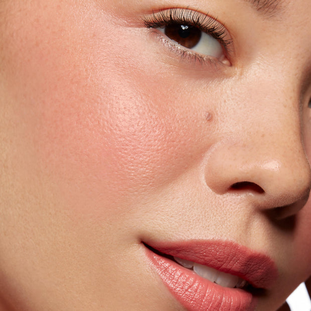 Baby Bunny ColourPop Lip and Cheek Balm tinting a model’s cheeks and lips a soft rosy pink, with a dewy cheek glow and satin lip finish in close-up studio lighting for a natural, fresh makeup look.