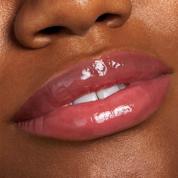 Glossy lips wear Bengal Lux Lip Oil, delivering a sheer rosy-pink tint and mirror shine in a close-up beauty shot; ColourPop Lux Lip Oil highlights hydrated, smooth texture with a non-sticky finish, ideal for everyday wear.