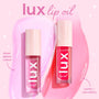 Two ColourPop Lux Lip Oil Top Hits tubes stand side by side, showing sheer glossy color and a comfy, non-sticky formula, with soft pink and bright fuchsia swatches on a pastel pink backdrop for hydrating shine.