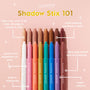Friday Feels Shadow Stix displayed upright in a row of ColourPop Shadow Stix, caps off to reveal creamy tips on a pastel pink background, showcasing a built-in sharpener and long-wear, multi-tasking eyeshadow stick for beginners or pros.