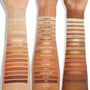 Golden Hour shadow palette by Colourpop swatched on three skin tones, showing a gradient of matte and shimmer neutral bronze, peach, and gold shades labeled from Glimmer to 7PM, illustrating pigmentation and payoff of Colourpop shadow palettes.