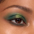 Eyelid wearing Just My Luck shades from the ColourPop Shadow Palette, blending emerald to lime metallic greens across the lid, with soft shimmer, defined lashes, and a groomed brow, illustrating bold pigment and seamless blend.