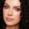 Close-up model wearing a rosy mauve eye look, blended shimmer and matte shades from the Blush Baby ColourPop Shadow Palette, with soft lashes, nude gloss lips, and natural freckles, shot in studio to showcase pigment payoff.