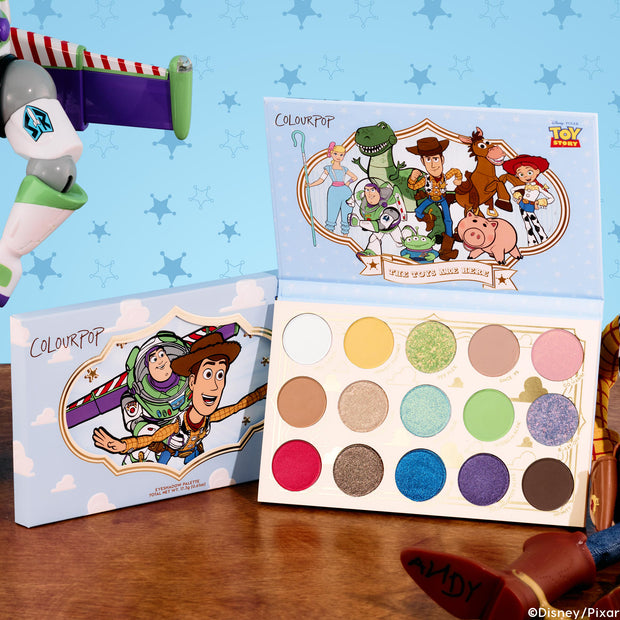 ColourPop The Toys Are Here shadow palette displaying a mix of bright and neutral matte and shimmer shades, packaged with Toy Story art of Woody, Buzz Lightyear, Jessie, Rex, and friends on a wood table against a sky-blue sheriff-badge backdrop.