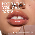 Glossy, smooth lips showcase the ColourPop Lip Scrub - Chocolate Milkshake, with a chocolate bar held near the mouth in a tight beauty close-up, emphasizing the chocolate milkshake flavor and a soft, freshly exfoliated finish.