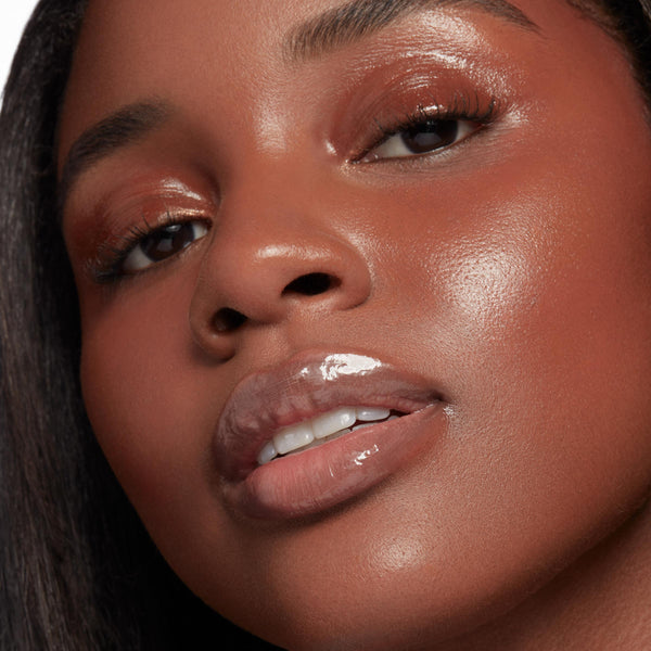Glossy, plumped lips wearing It’s a Date, ColourPop So Juicy Plumping Glossy Lip Oil, catching light with a glass-like shine, shown in a close-up beauty shot with dewy skin and warm copper eyeshadow for a fresh, full-lip look.