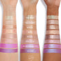 Boo-Kay Jelly Much Shadow swatch gleams on three forearms, shown with labeled rows of other shades, displaying a shimmery pink finish across light, medium, and deep skin tones for easy comparison of ColourPop Jelly Much Shadow colors.