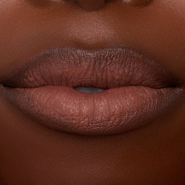 Close-up lips wearing ColourPop Ultra Blotted Lip in Espresso Martini, a coffee-brown shade with a soft-matte, blotted finish and gently diffused edges, shown in studio lighting to showcase the lightweight, blurred-effect formula.