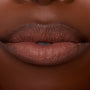 Close-up lips wearing ColourPop Ultra Blotted Lip in Espresso Martini, a coffee-brown shade with a soft-matte, blotted finish and gently diffused edges, shown in studio lighting to showcase the lightweight, blurred-effect formula.
