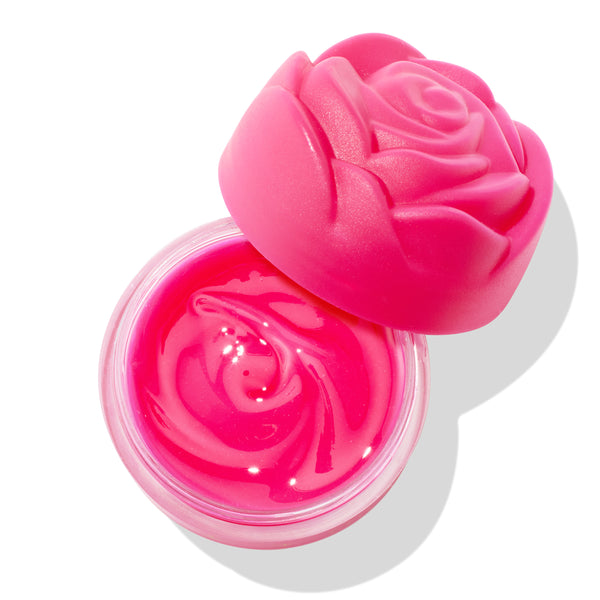 Enchanted Rose ColourPop Lip Mask sits open, revealing a glossy hot pink balm with a rose-swirled texture, while a matching fuchsia rose-shaped cap rests askew on the clear round jar against a bright white background.