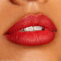 Bold red lips defined by ColourPop Lippie Pencil in Bossy, slightly parted to show teeth, in a tight studio close-up swatch for The Lil Box of Lippie Pencils, highlighting a smooth matte finish and crisp lip line.