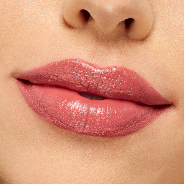 Lips wearing ColourPop Lippie Stix It’s Giving, a rosy pink nude shade with a creamy, slightly glossy finish, evenly applied in a tight close-up against clean skin to showcase smooth pigment and hydration.
