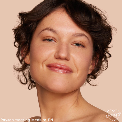 Model’s face wearing Medium 11 N, showing a fresh, dewy finish from the ColourPop Pretty Fresh Tinted Moisturizer; light coverage evens skin tone with a natural glow in a close-up against a soft beige backdrop.