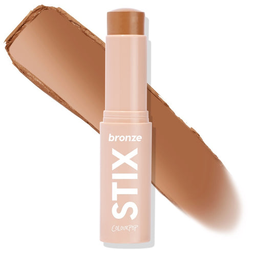 ColourPop Bronzer Stix in Moonstone Beach standing uncapped, the twist-up cream bronzer bullet leaving a warm tan swipe behind it, shown close-up on a white background for shade reference; ideal for sun-kissed contour.