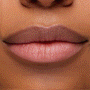 Model’s lips wear ColourPop pH Lip Balm, Sing, tinting to a custom soft pink with a glossy, hydrated finish; close-up studio shot on medium skin showcases the pH‑reactive color, smooth texture, and subtle shine.