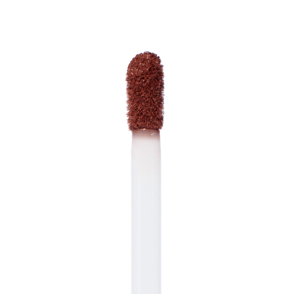 Doe-foot applicator coated with Toast, a warm brown ColourPop Ultra Matte Lip, showcasing its velvety, rich pigment in a macro close-up against a white background.