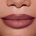 Close-up of full lips wearing ColourPop Opposites Attract Lippie Stix, showing a smooth, satin-matte mauve finish inspired by Twilight tones on medium skin, highlighting even coverage and creamy texture for everyday makeup looks.