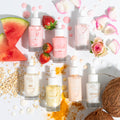 Strawberry Face Milk bottle standing center, labeled Fourth Ray Beauty, surrounded by fresh strawberries, rose petals, and assorted flavors on a white backdrop - ColourPop Face Milk, hydrating strawberry formula for glowing, dewy skin.