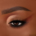 Rose-gold shimmer and warm terracotta mattes sweep across a single eye, creating a soft wing with black liner and lush lashes, showcasing the By The Rosé ColourPop Shadow Palette in a close-up beauty shot.